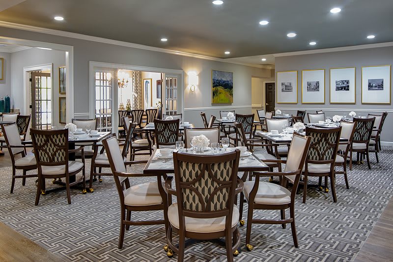 An elegant dining room with neatly arranged tables and chairs.