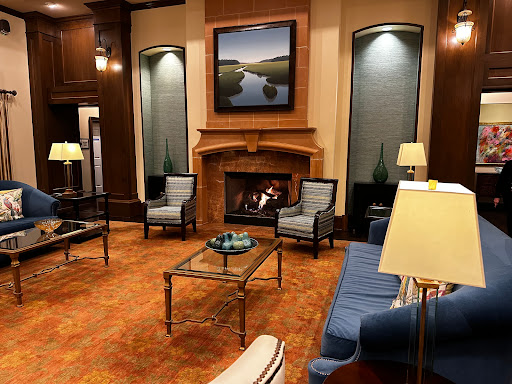 A cozy living room setting featuring elegant furniture, a warm fireplace, and beautiful artwork.