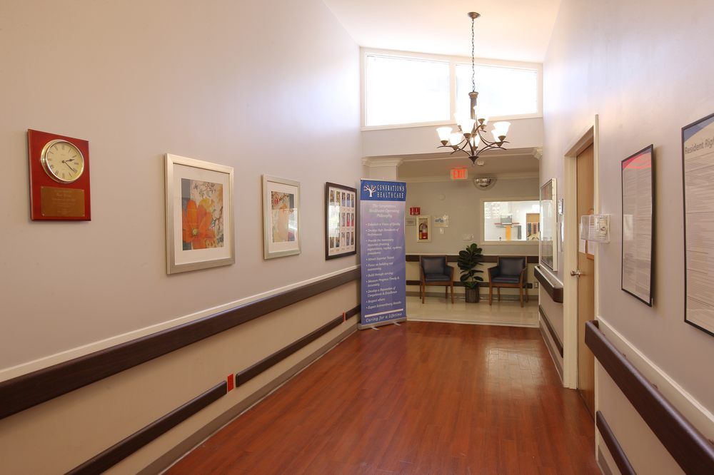 A well-lit hallway with artwork on the walls and wooden flooring.