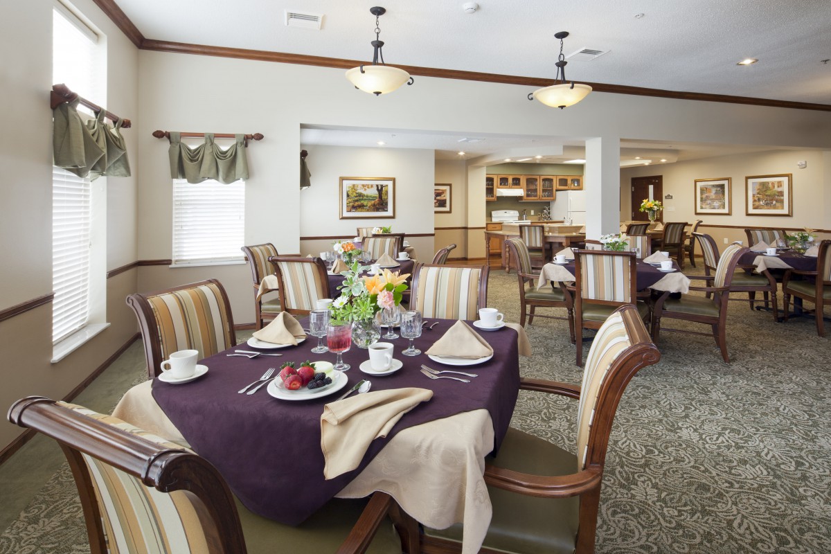 An elegantly decorated dining room with a neatly set table and comfortable chairs.
