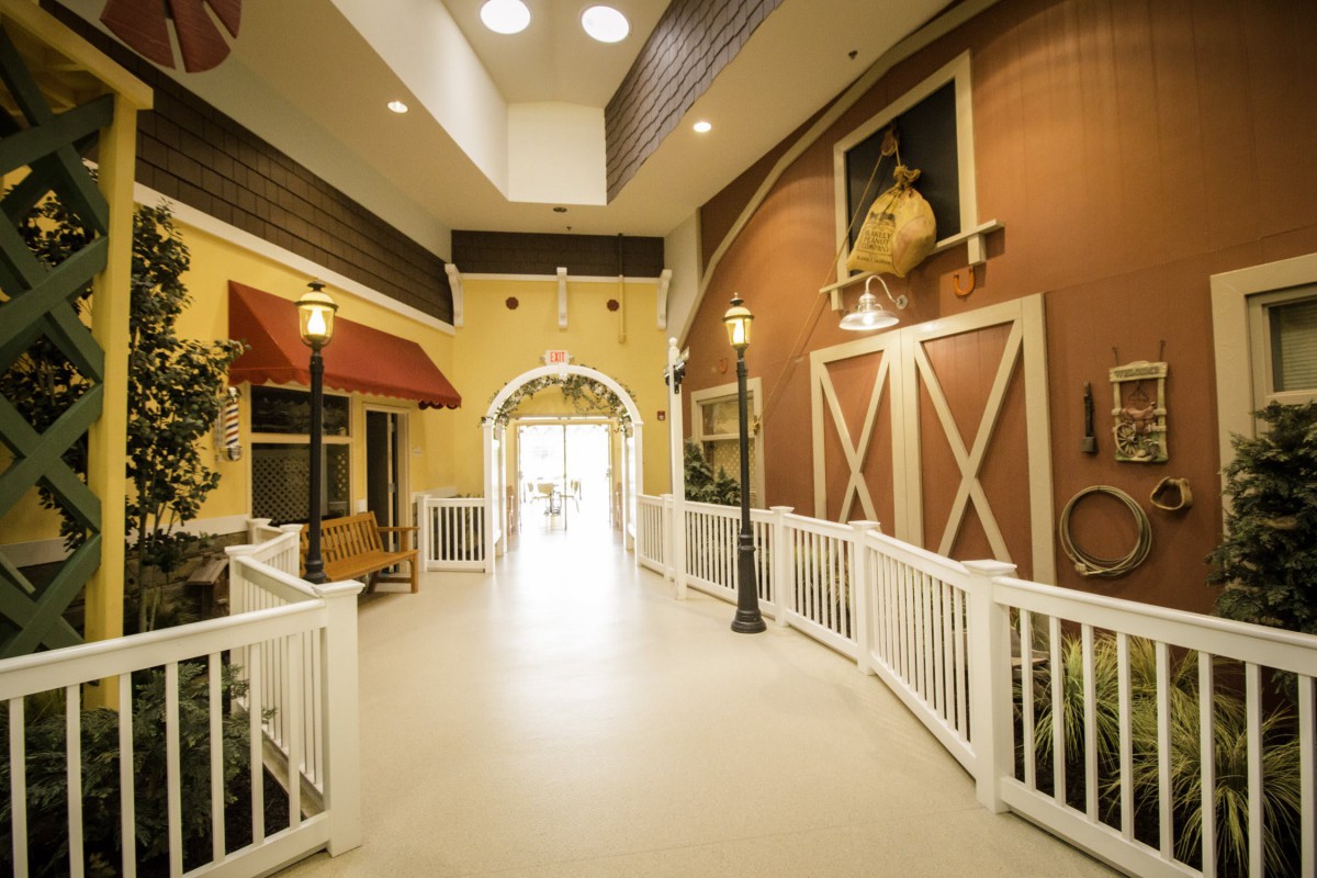 A barn-themed indoor hallway with rustic decor and warm lighting.