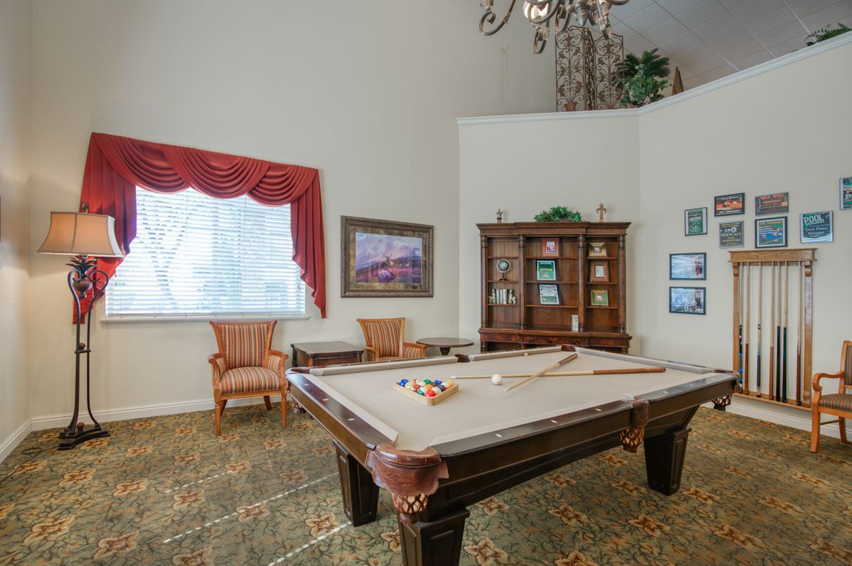 A cozy game room featuring a pool table, elegant furniture, and artwork on the walls.