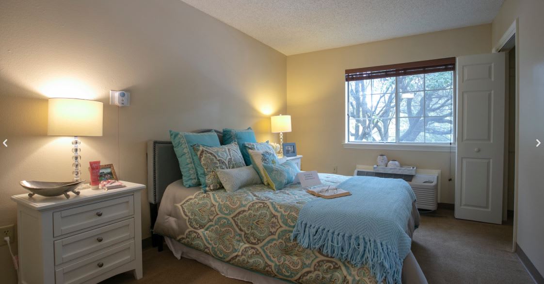A cozy bedroom with patterned bedding and soft lighting.