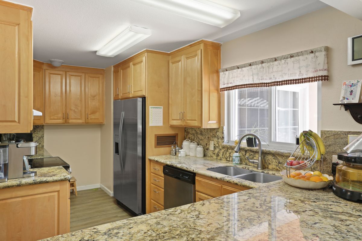 Modern kitchen with wooden cabinets and granite countertops.