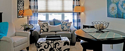 A cozy and stylish living room featuring a comfortable sofa adorned with decorative pillows, complemented by elegant curtains and warm lighting.