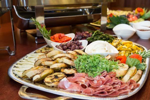 A beautifully arranged platter featuring a variety of grilled vegetables, meats, and cheese.