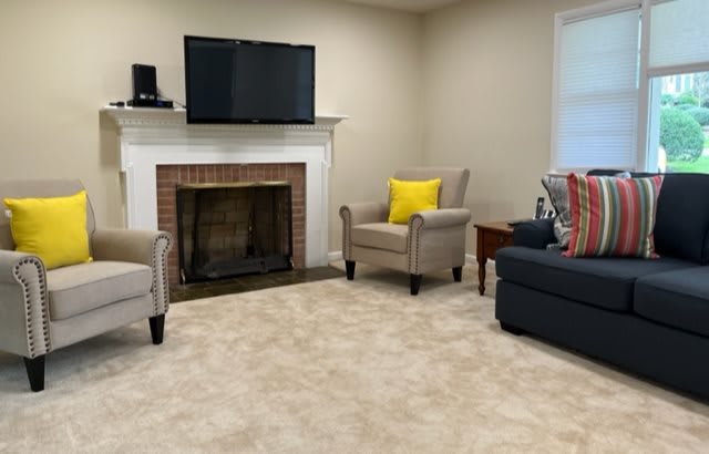 A cozy living room with a fireplace, TV, and comfortable seating.