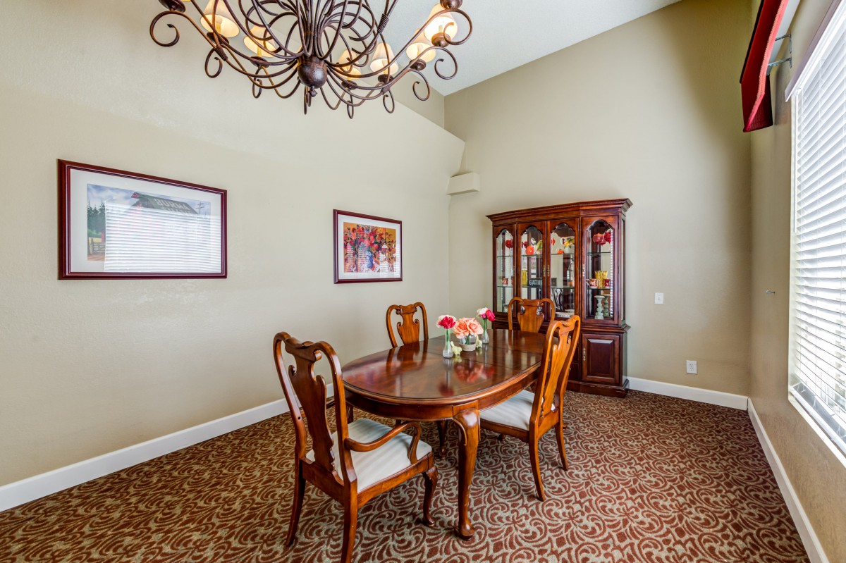 A classic dining room with elegant wooden furniture and a chandelier.