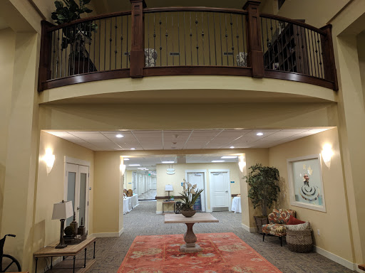 A spacious and elegantly designed lobby with a balcony, featuring modern decor and comfortable seating.