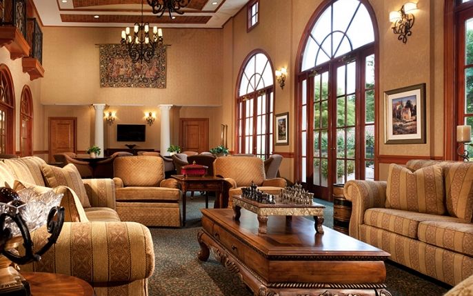 A luxurious hotel lobby with elegant furniture and large arched windows.