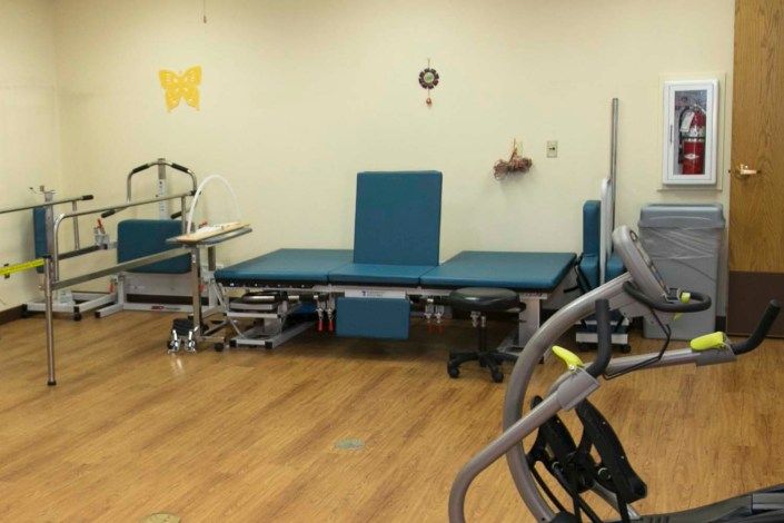 A physical therapy room equipped with a therapy table and exercise equipment.