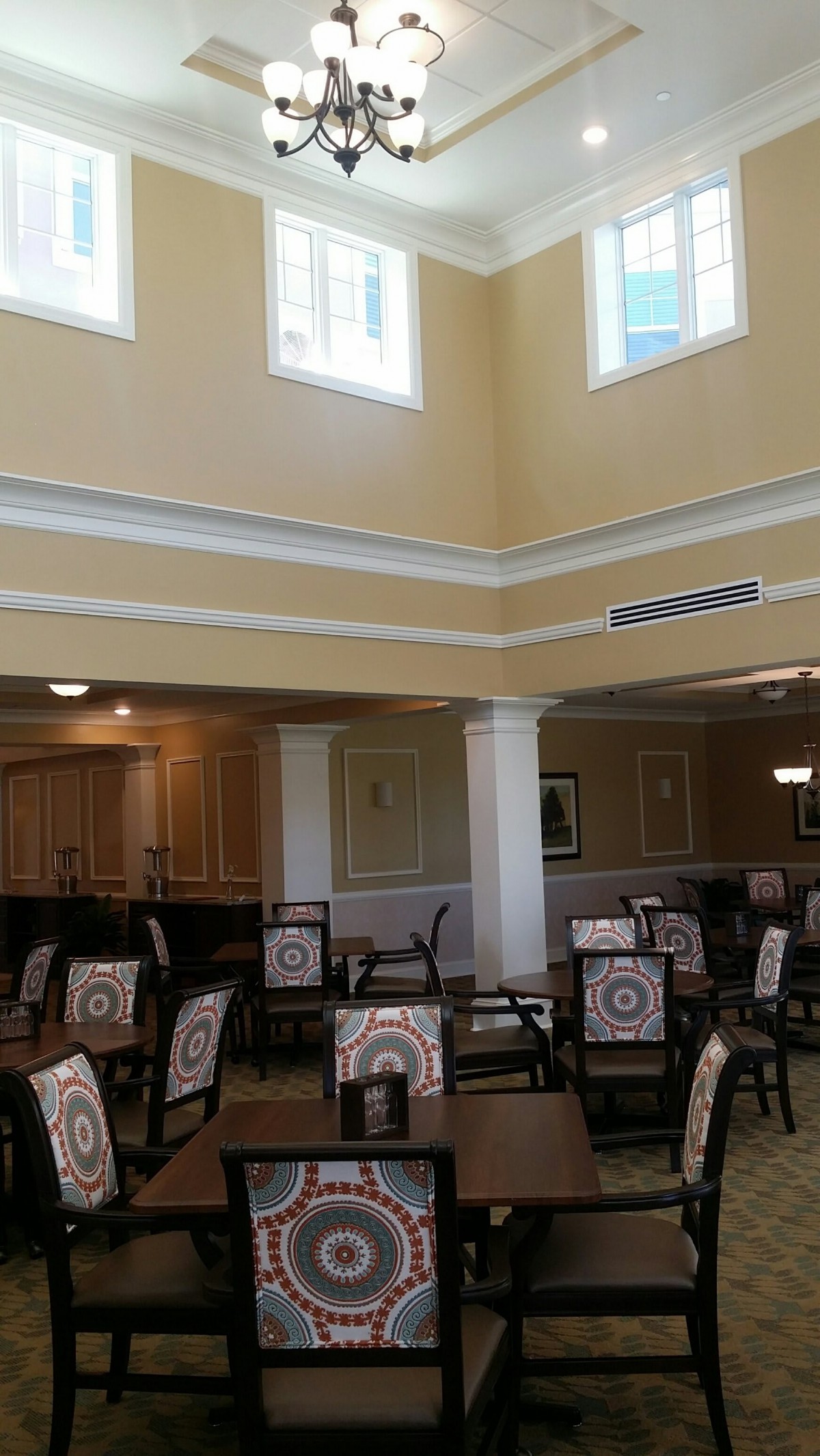 Spacious dining area with high ceilings and multiple tables and chairs.