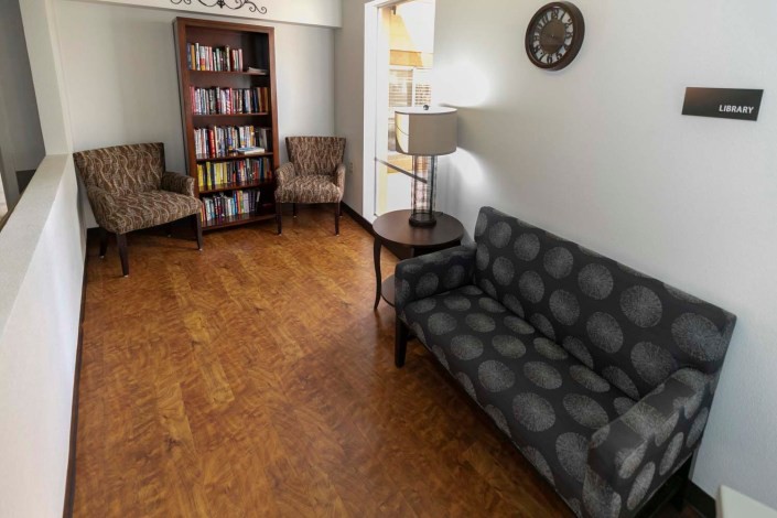 A cozy living room with a sofa, chairs, and a well-stocked bookcase.