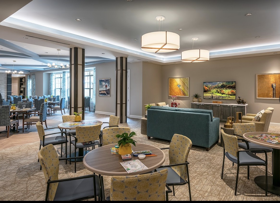 A modern lounge area with comfortable seating, tables, and ambient lighting.