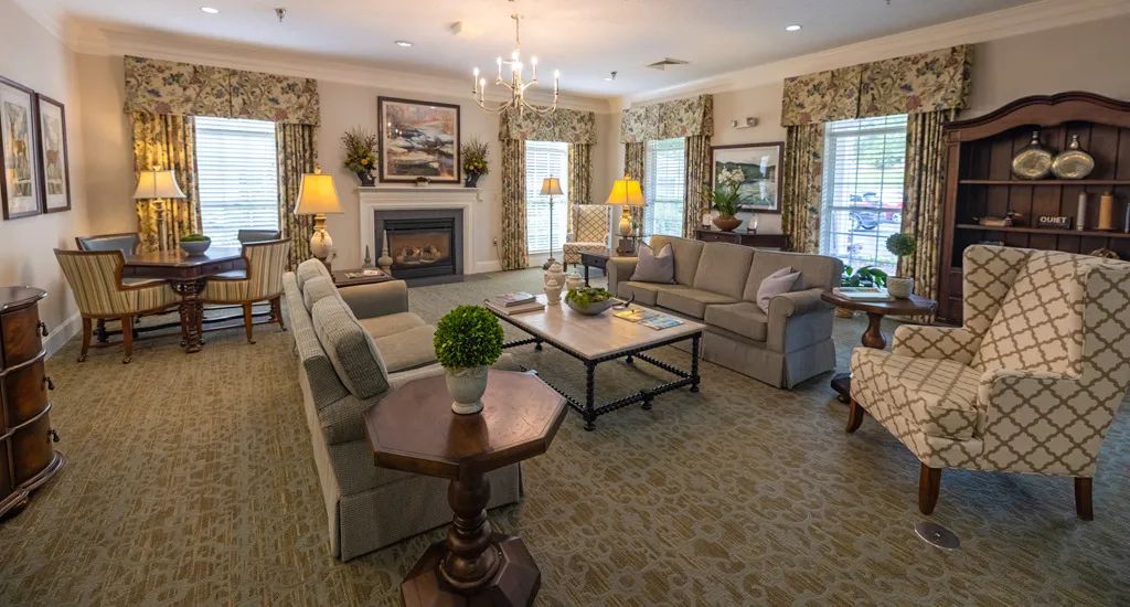 A cozy and elegantly designed living room with comfortable sofas, a central coffee table, and a warm fireplace.