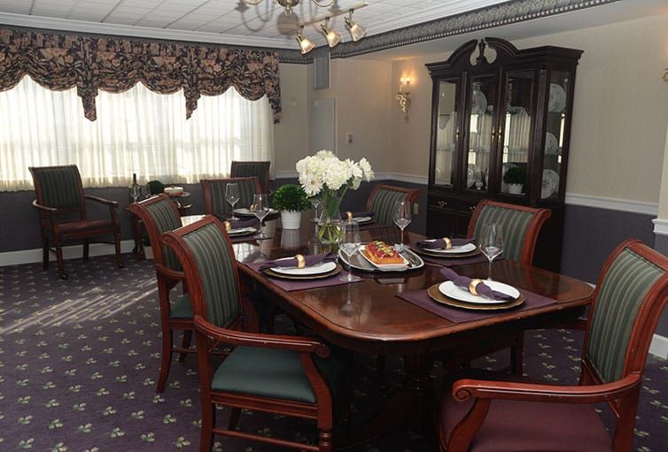 A classic-style dining room with an elegant table setting and a chandelier.