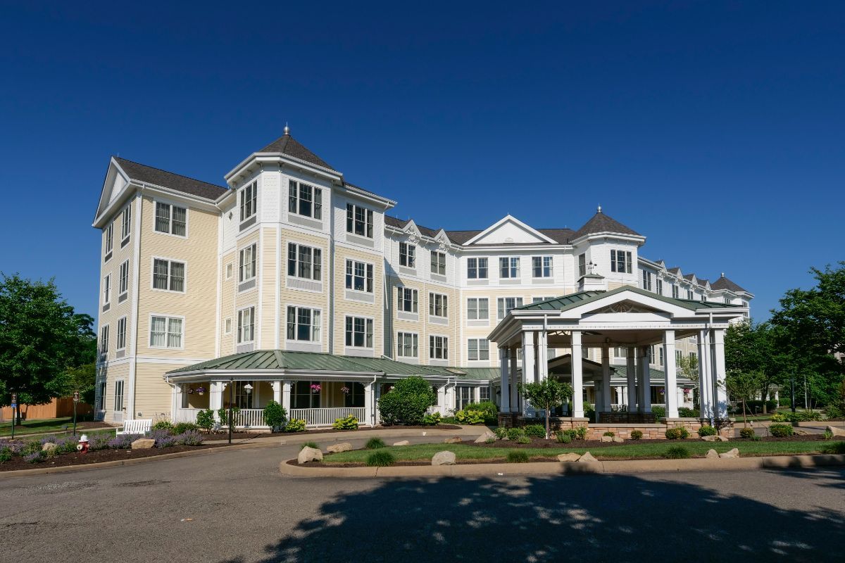 A large, multi-story hotel with a classic architectural design against a clear blue sky.