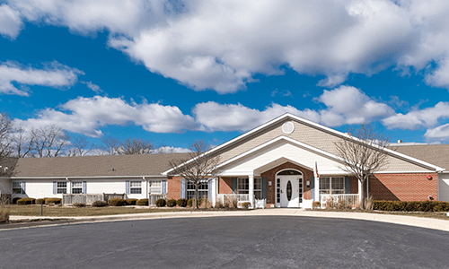 A single-story building with a gabled roof under a partly cloudy sky.