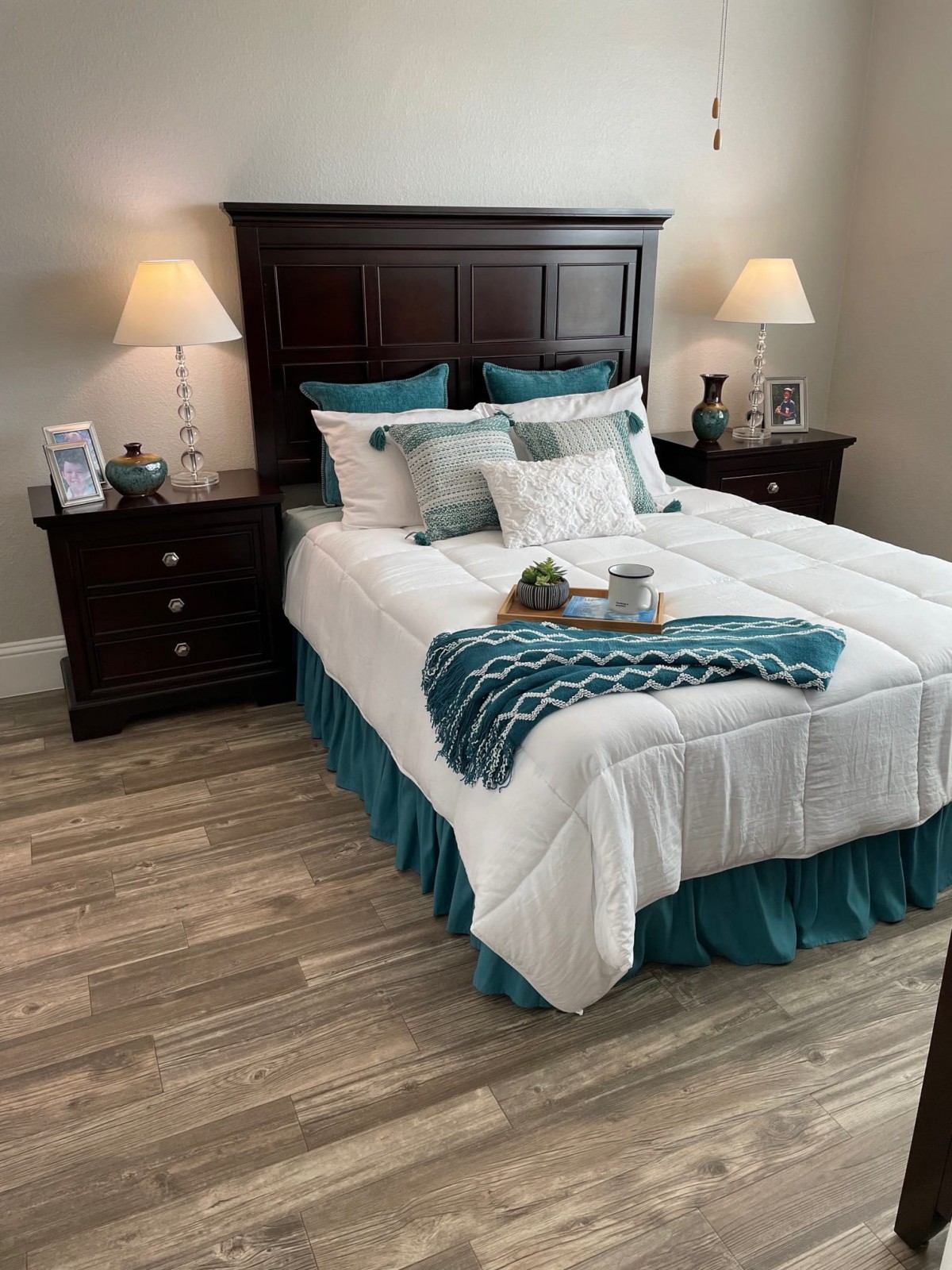 A cozy bedroom with a neatly made bed, side tables with lamps, and tasteful decor.
