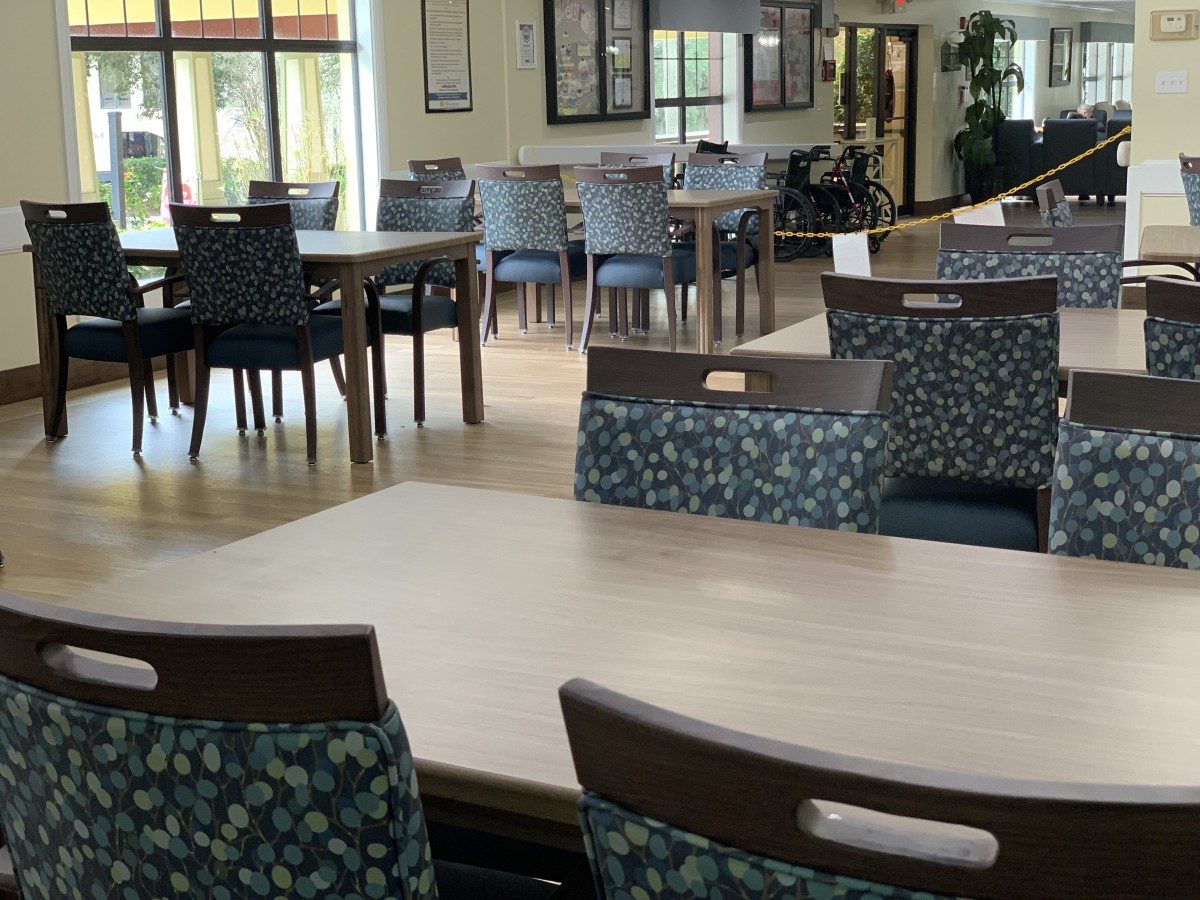 A spacious dining area with multiple tables and chairs, featuring a bright and inviting atmosphere.