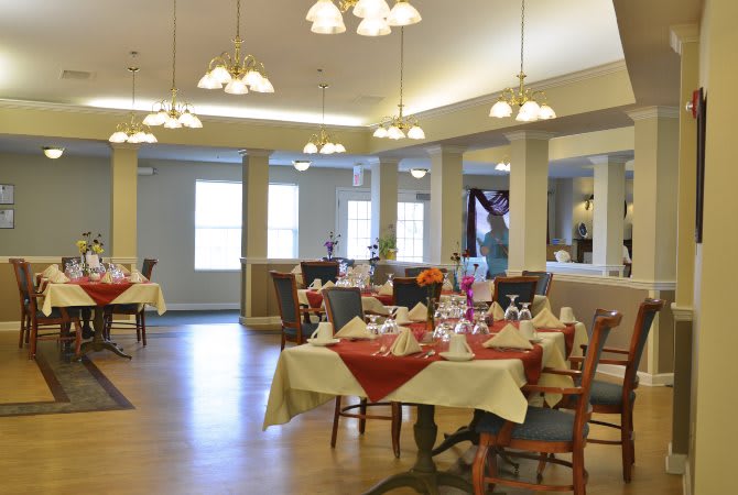 A well-decorated dining room with elegantly set tables and chairs, ready for guests.