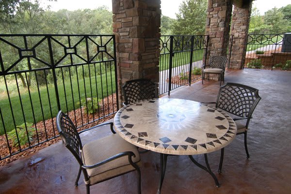 A cozy outdoor patio with a decorative table and chairs overlooking a scenic landscape.