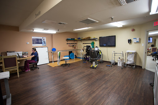 A spacious therapy room equipped with exercise materials and seating arrangements for rehabilitation activities.