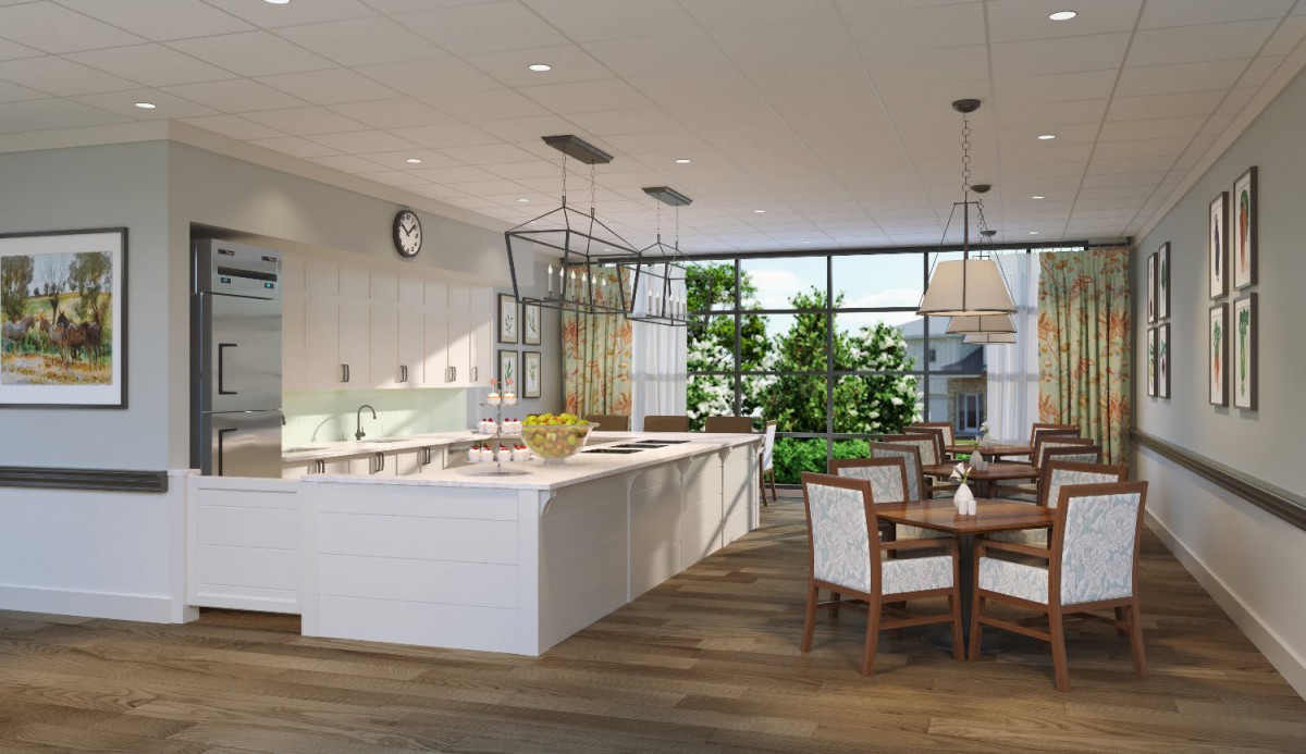 A modern kitchen with an open dining area, featuring white cabinetry and ample natural light.