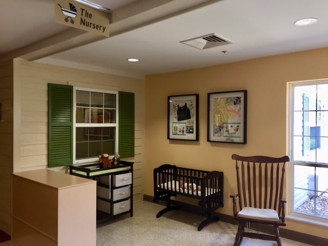 A cozy nursery room featuring a crib and a rocking chair.