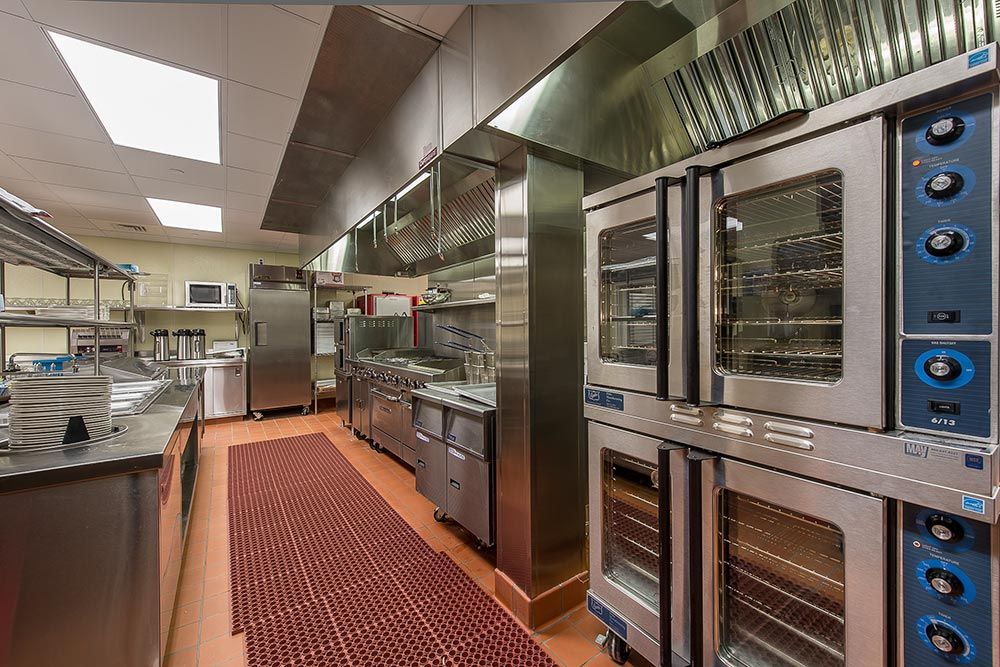 A modern commercial kitchen with stainless steel appliances and professional equipment.