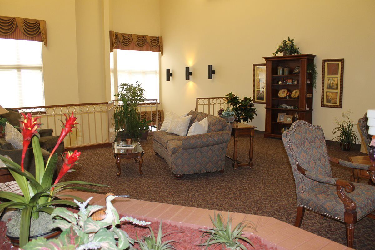 A cozy living room with comfortable seating and decorative plants.