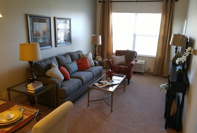 A cozy living room with a sofa, armchair, and coffee table.