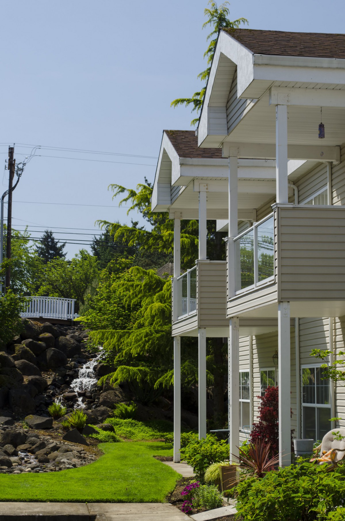 A modern house with balconies surrounded by lush greenery.