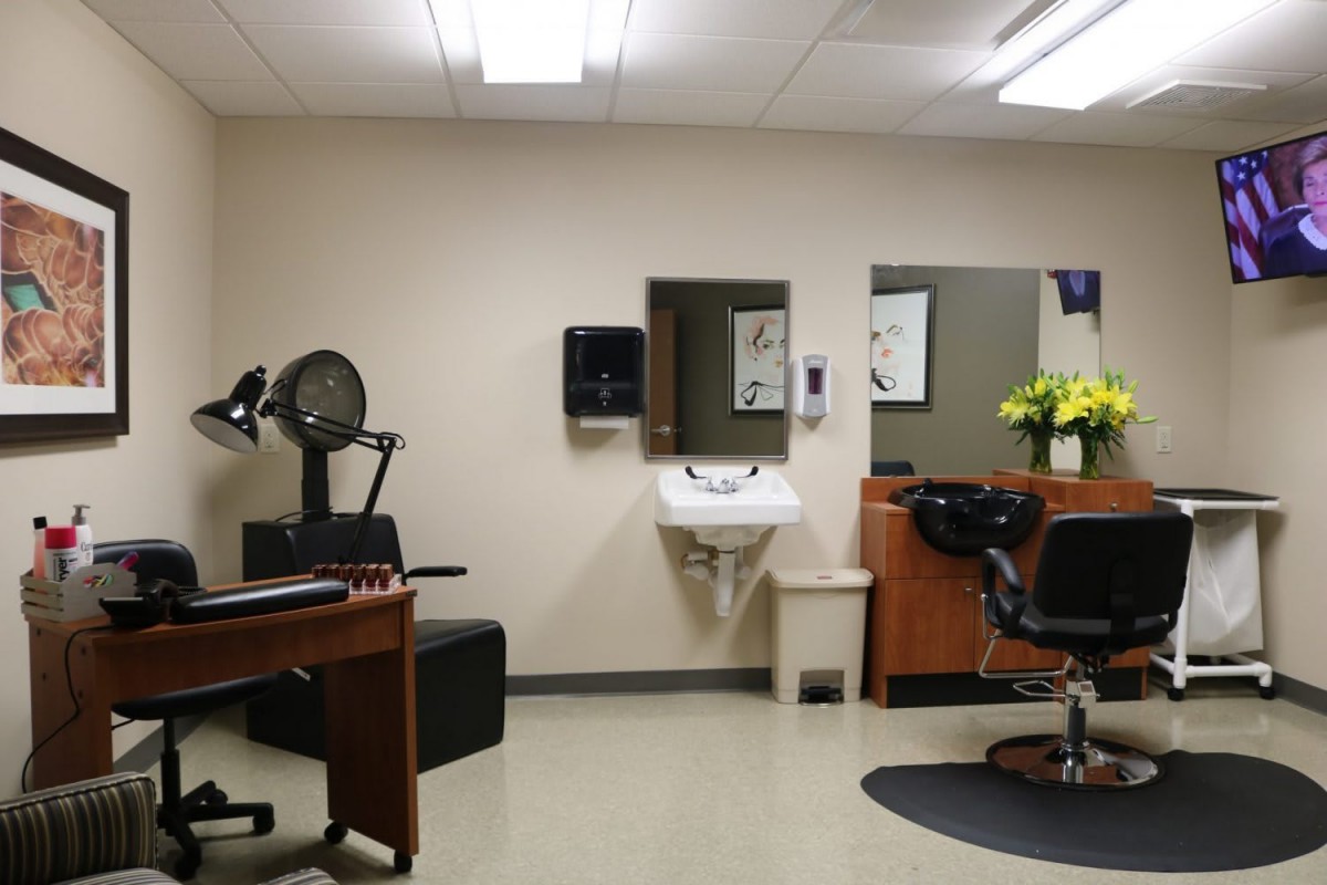 A tidy and empty hair salon interior with chairs, mirrors, and a sink.