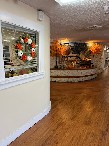 A warm and inviting interior decorated for autumn, featuring a seasonal wreath and cozy wooden flooring.