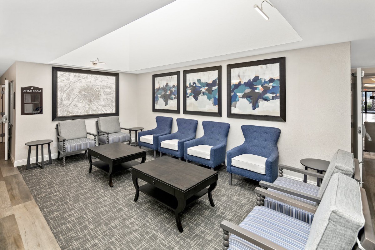 A modern waiting room with comfortable seating and abstract artwork.