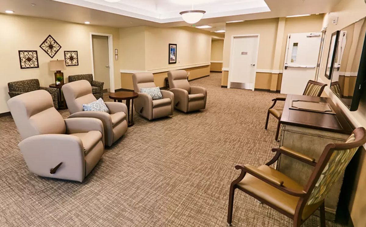 A waiting room with comfortable recliner chairs and a carpeted floor.