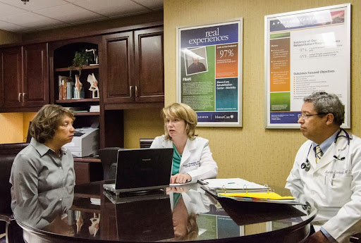 Healthcare professionals discussing patient information in a medical office.