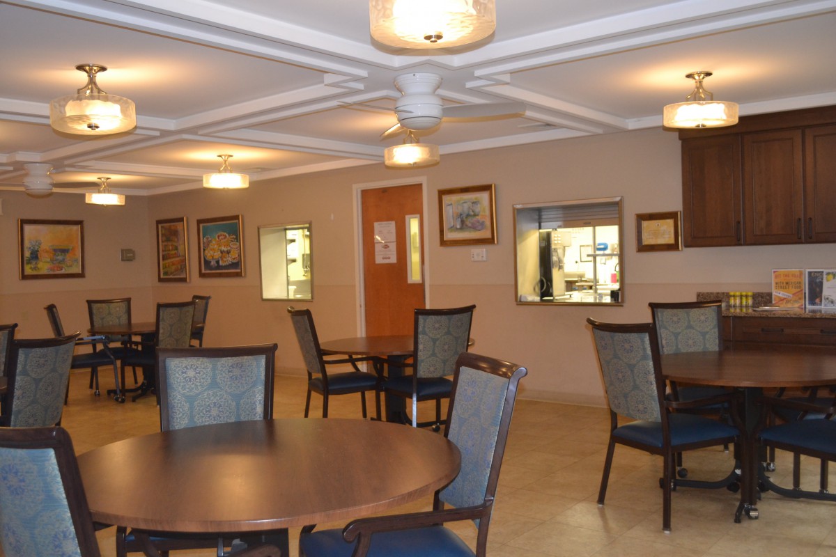 A well-lit dining area with tables and chairs arranged for visitors.