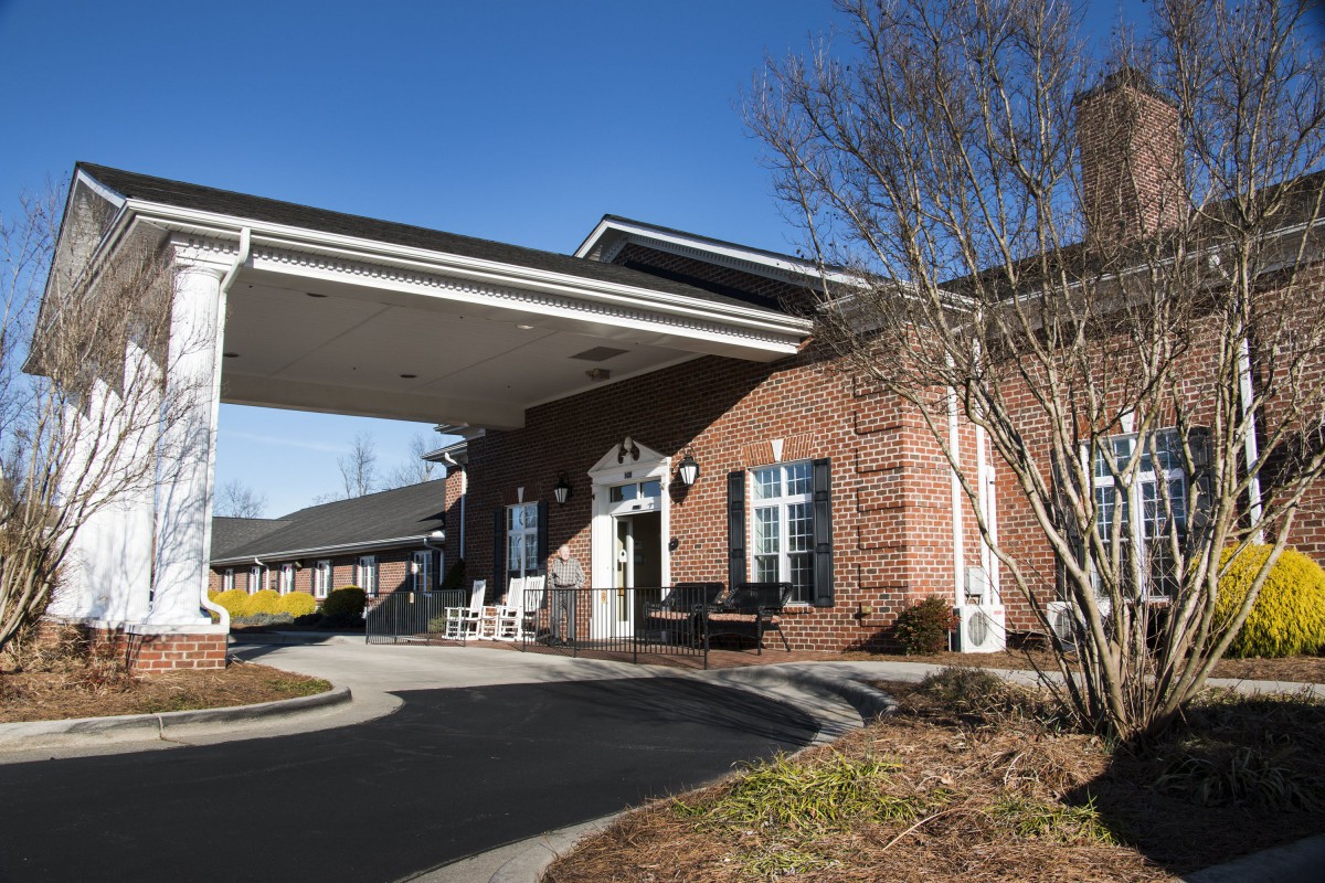 A brick building with a covered entrance and driveway.
