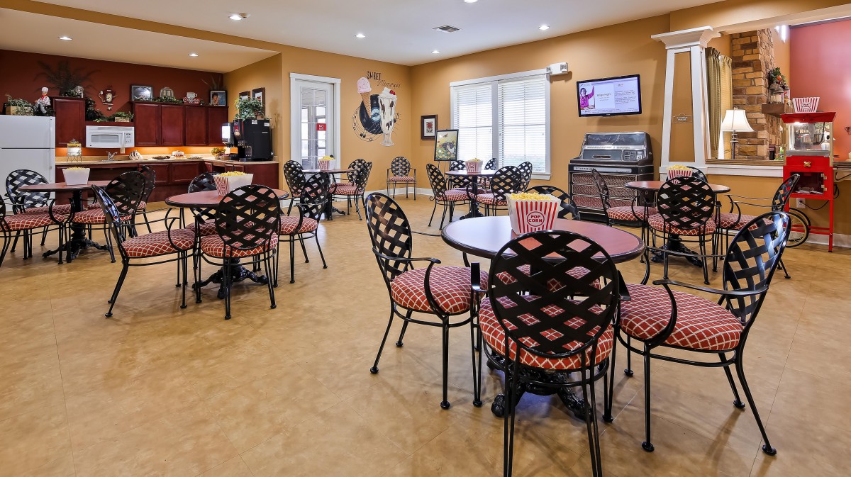 An empty cafe interior with patterned chairs and round tables.