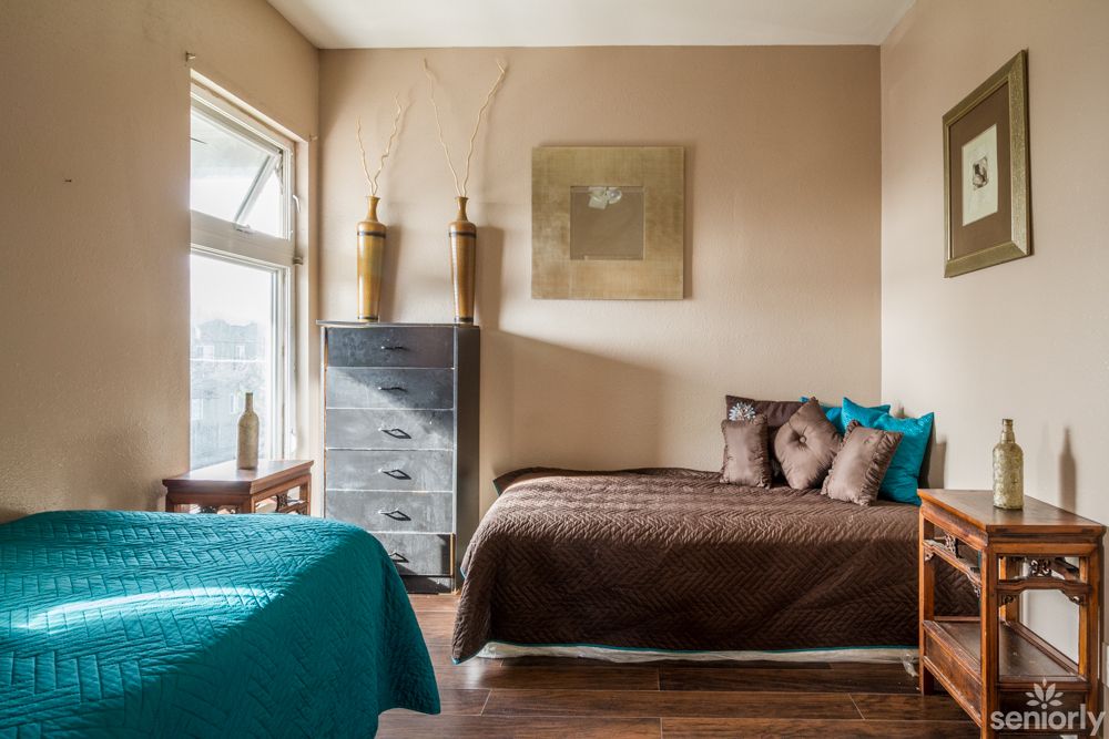 A modern bedroom with two beds, featuring elegant decor and wooden flooring.