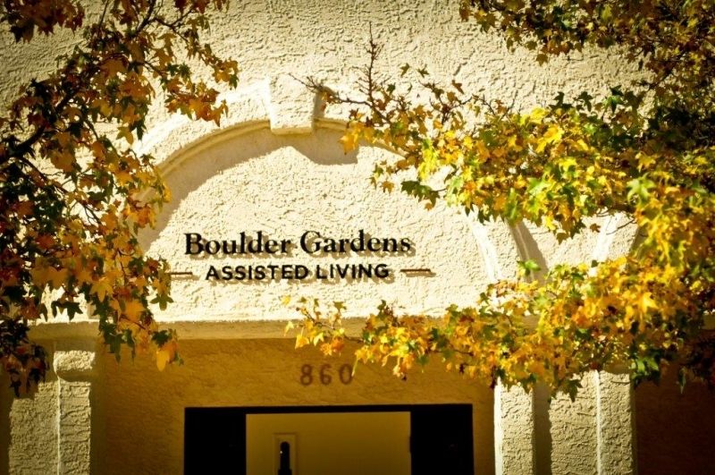 Entrance to Boulder Gardens Assisted Living with autumn leaves.