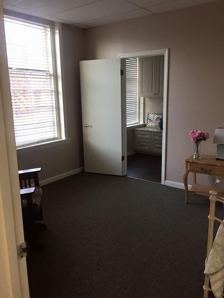 An empty room with a window, door, table, and chair.