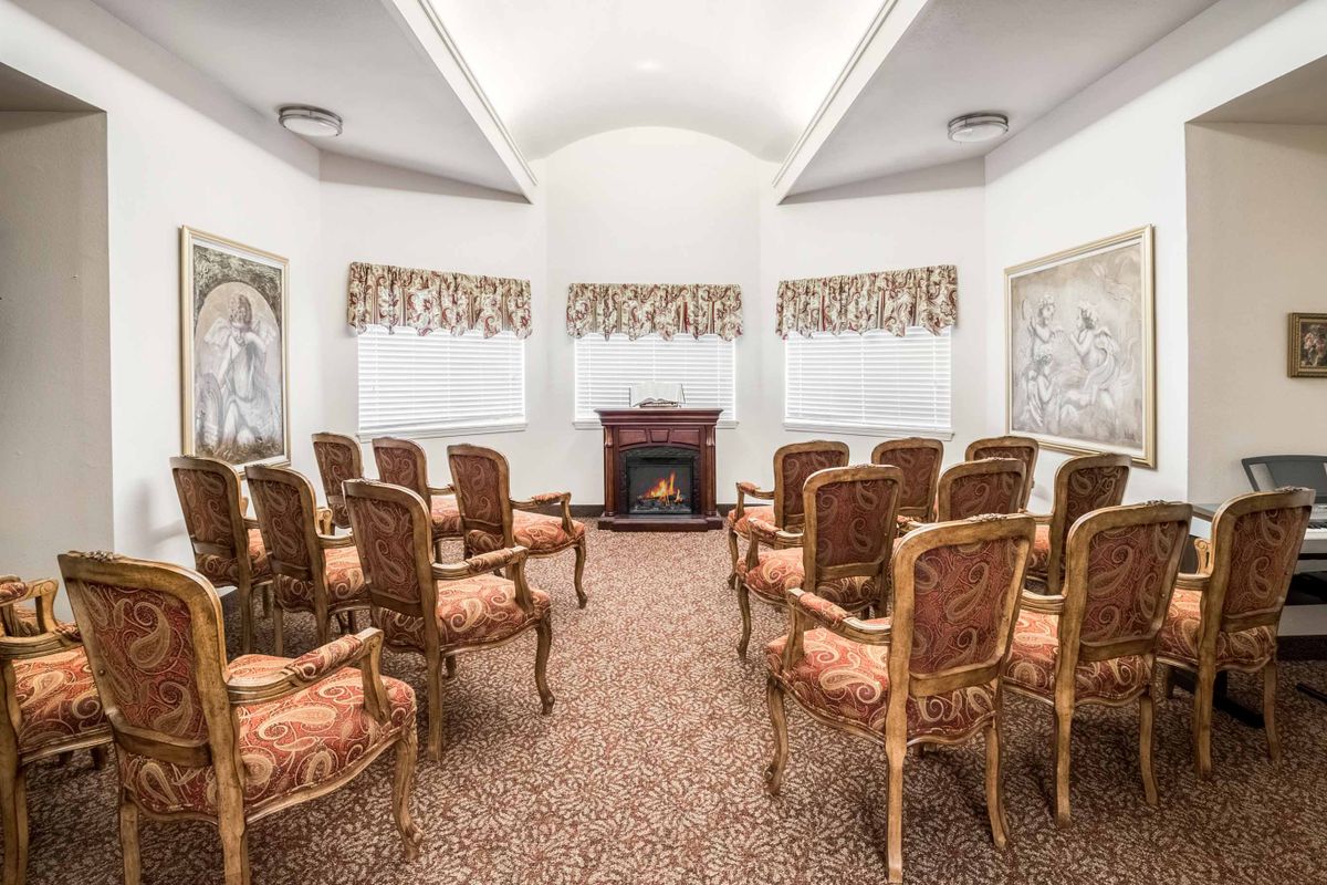 A neatly arranged meeting room with ornate chairs and decorative elements.
