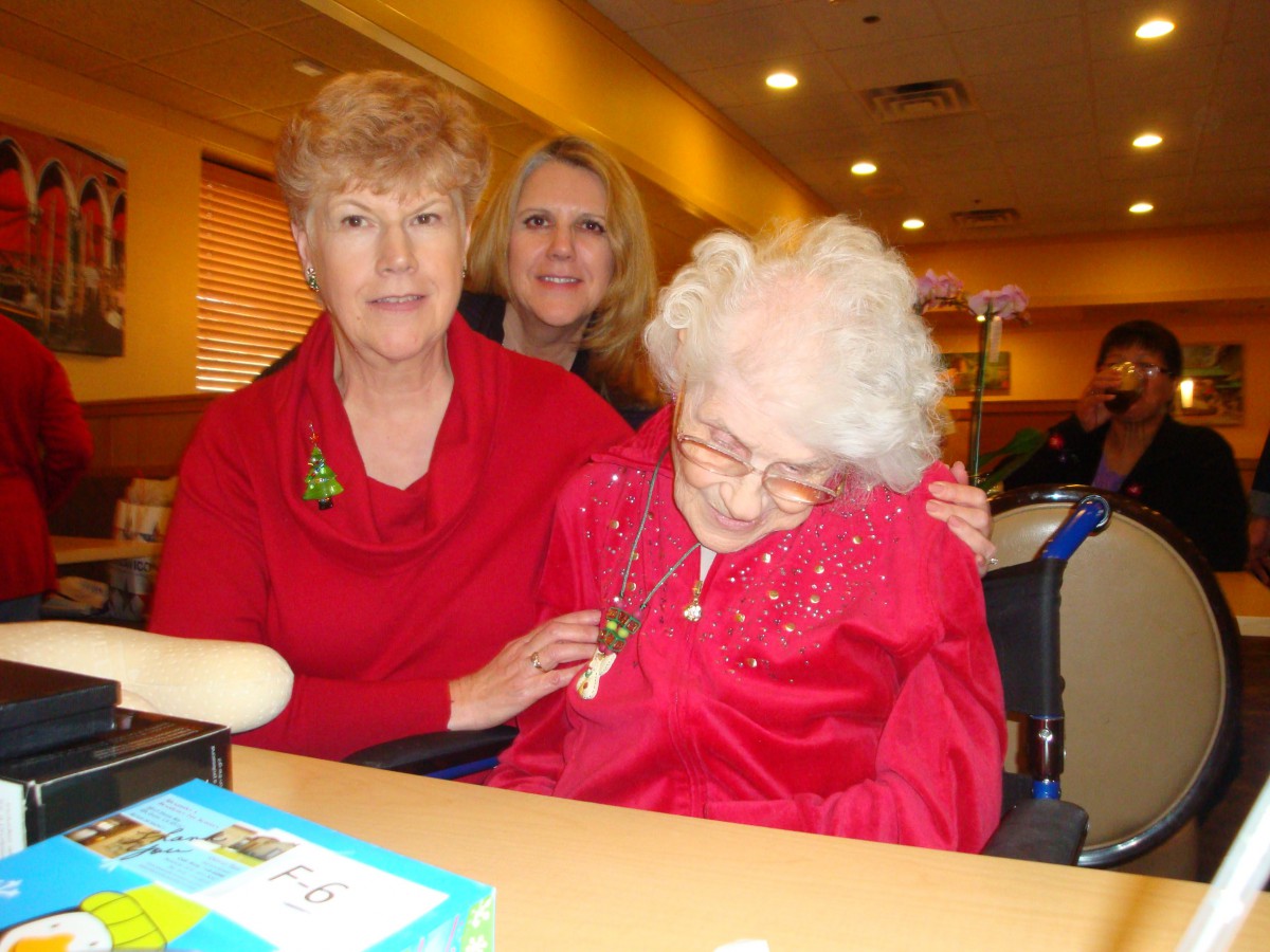 A group of women gathering together indoors, possibly celebrating an occasion.