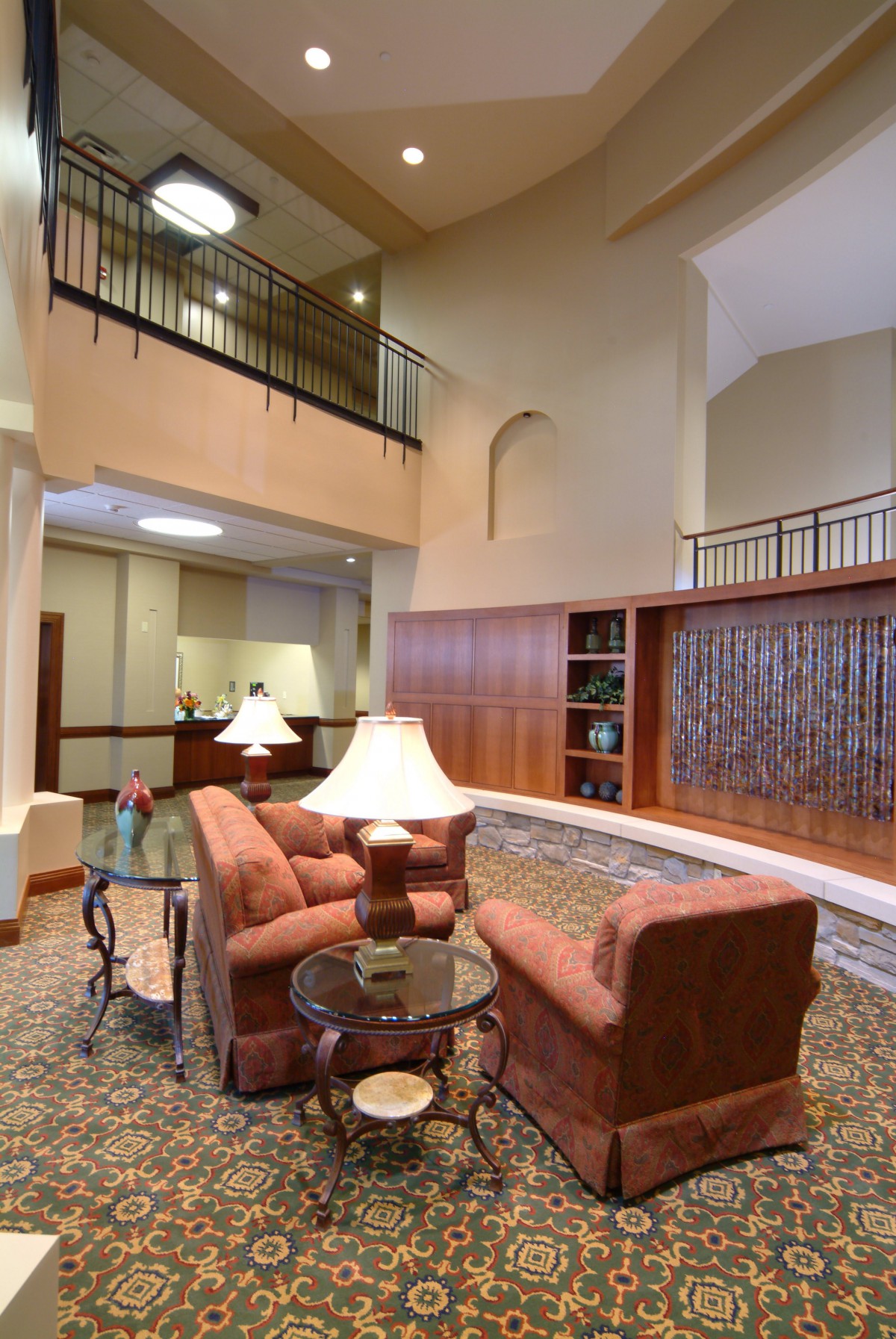 A spacious lobby featuring comfortable seating, stylish lamps, and built-in bookshelves.