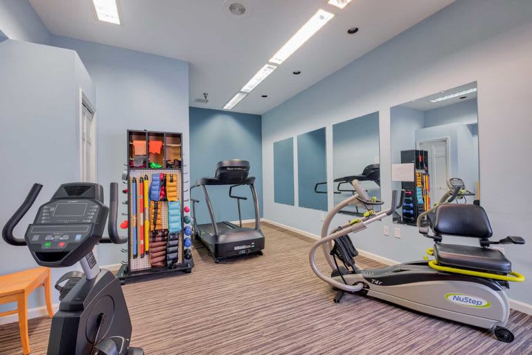A modern fitness room equipped with treadmills and mirrors.