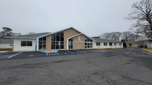 A modern community center building with large windows, set in a foggy atmosphere.