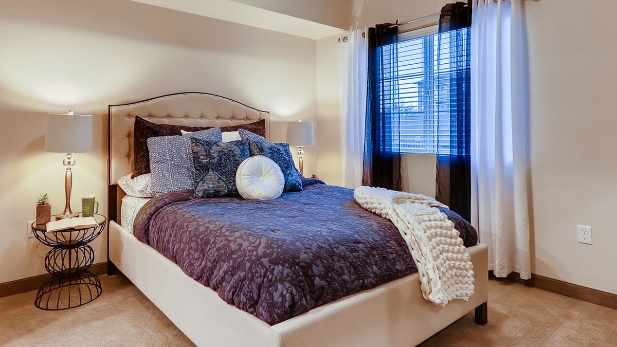 A cozy and well-decorated bedroom with a plush bed and stylish pillows.